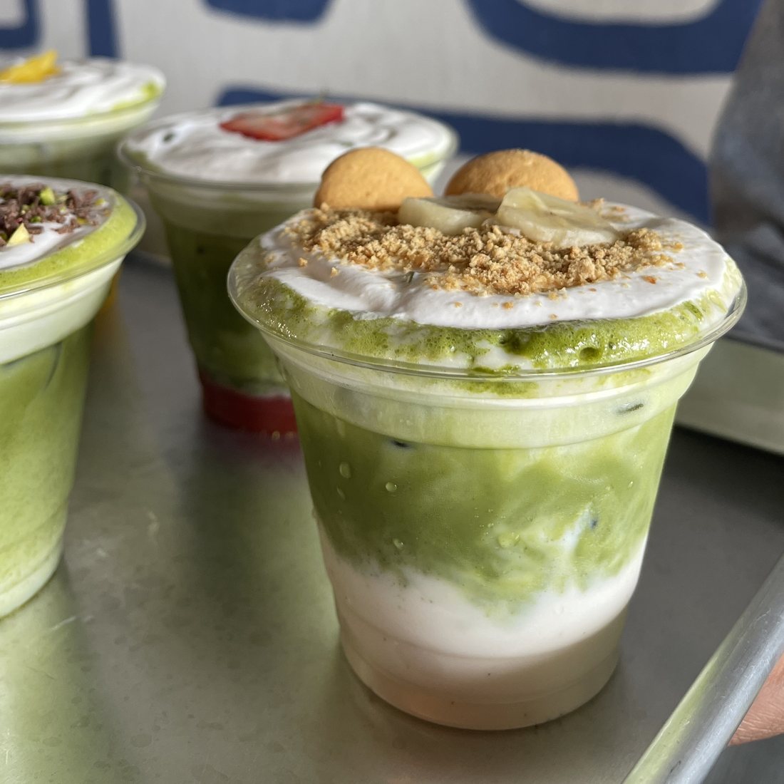Banana pudding matcha latte topped with vanilla wafers and fresh banana at Dèlf Café, Sunrise, FL