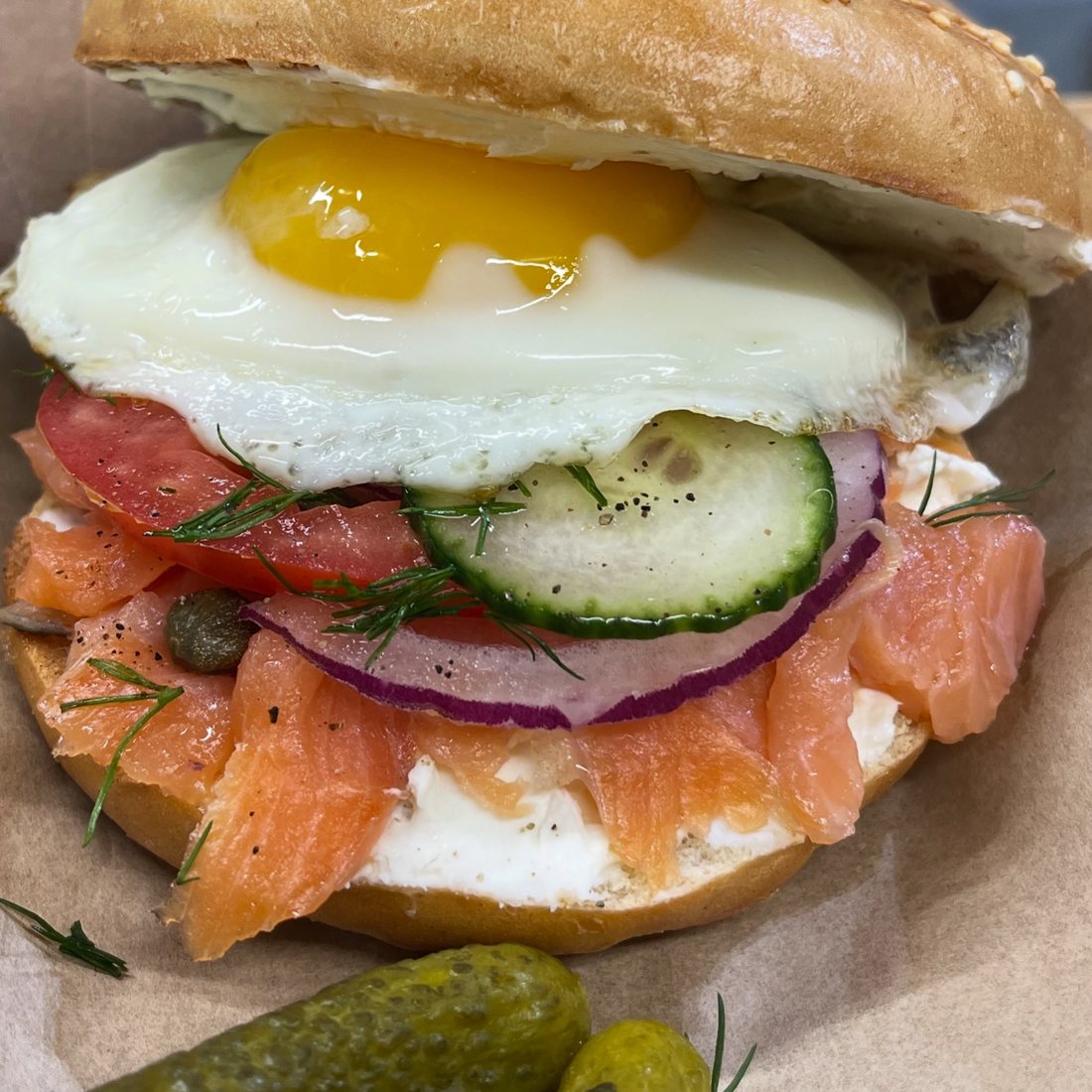 Dèlf Surf Bagel with smoked salmon, sunny side up egg, cucumber, red onion and capers at Dèlf Café