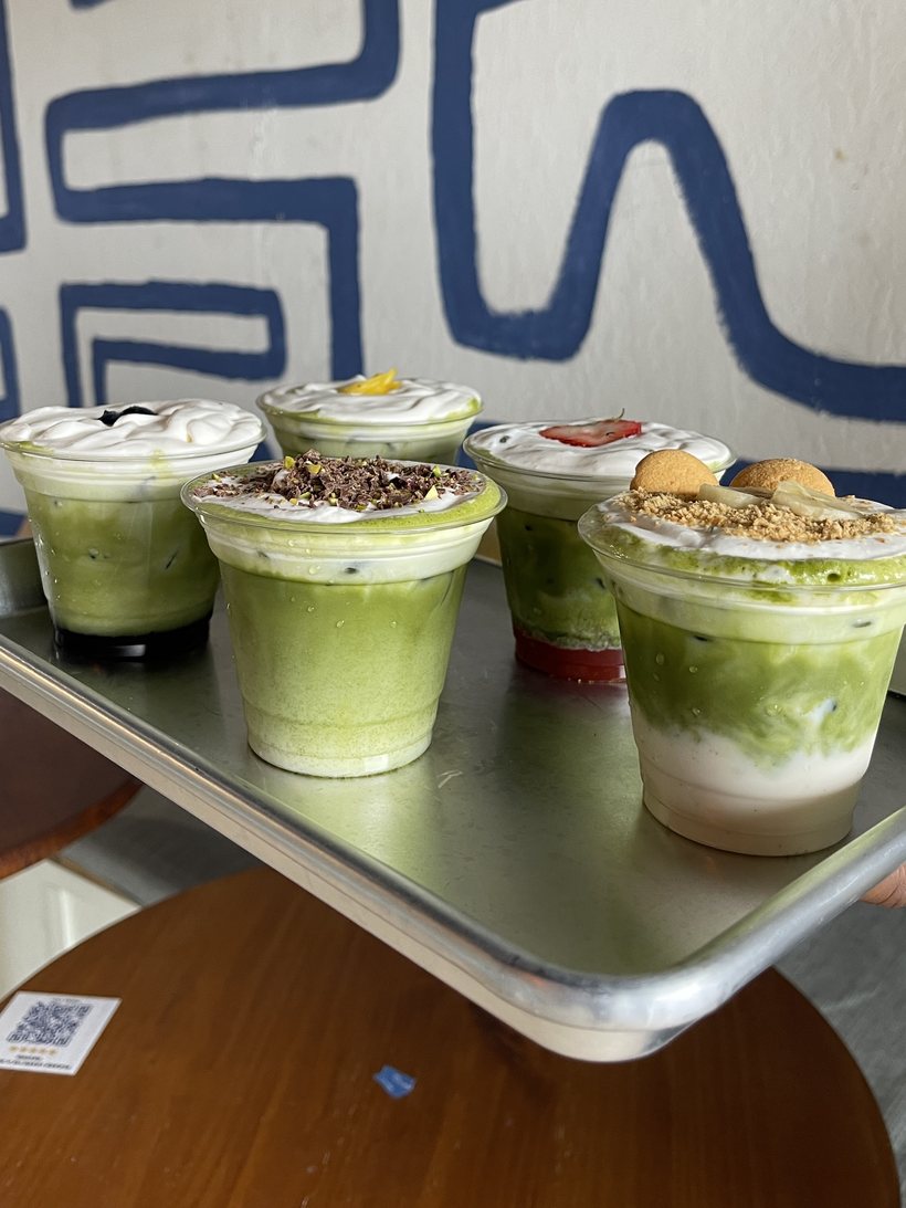Flight of specialty matcha lattes on a tray at Dèlf Café in Sunrise, FL